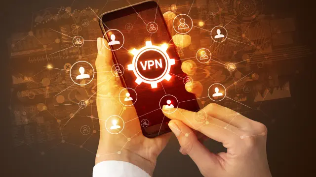 Dłonie trzymające smartfon z ikoną VPN i siecią połączeń użytkowników.